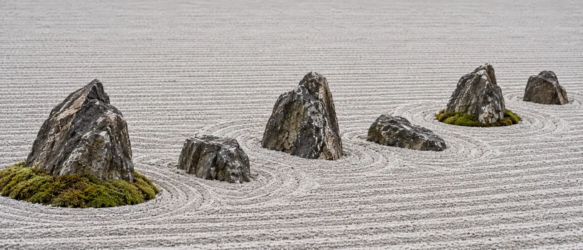 Six weathered stones set in a loose line across raked gravel