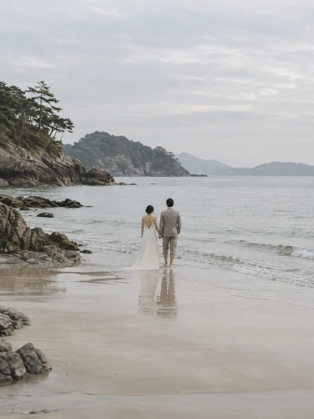 A barefoot beach ceremony at the water's edge during golden hour